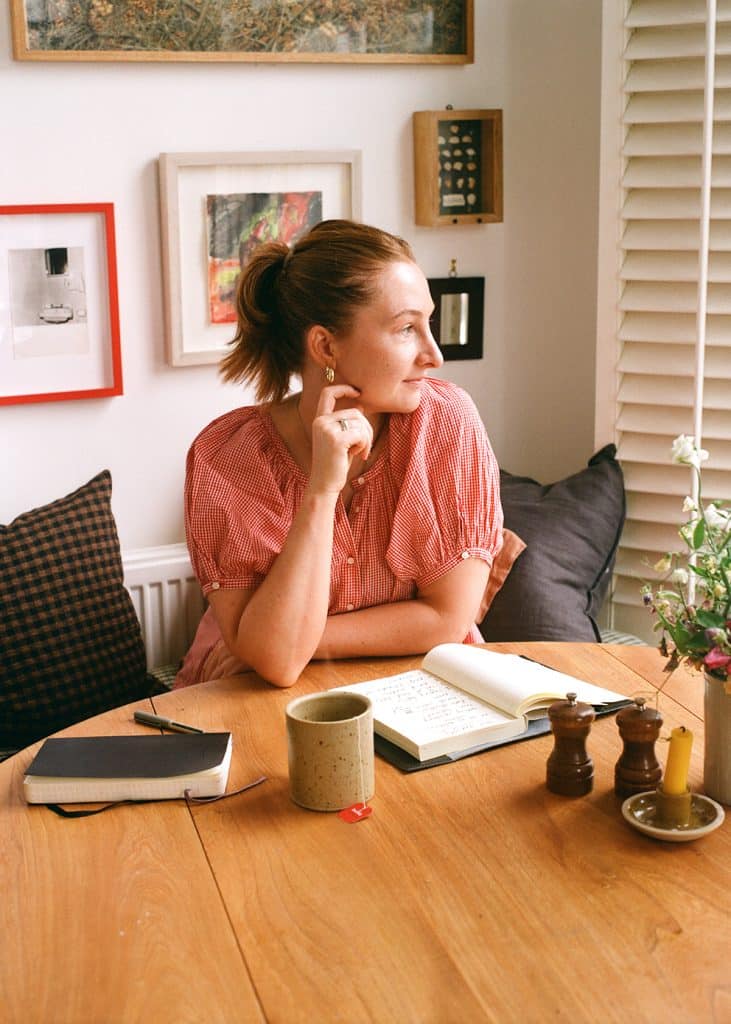 A portrait of Kitty Coles sitting at a table