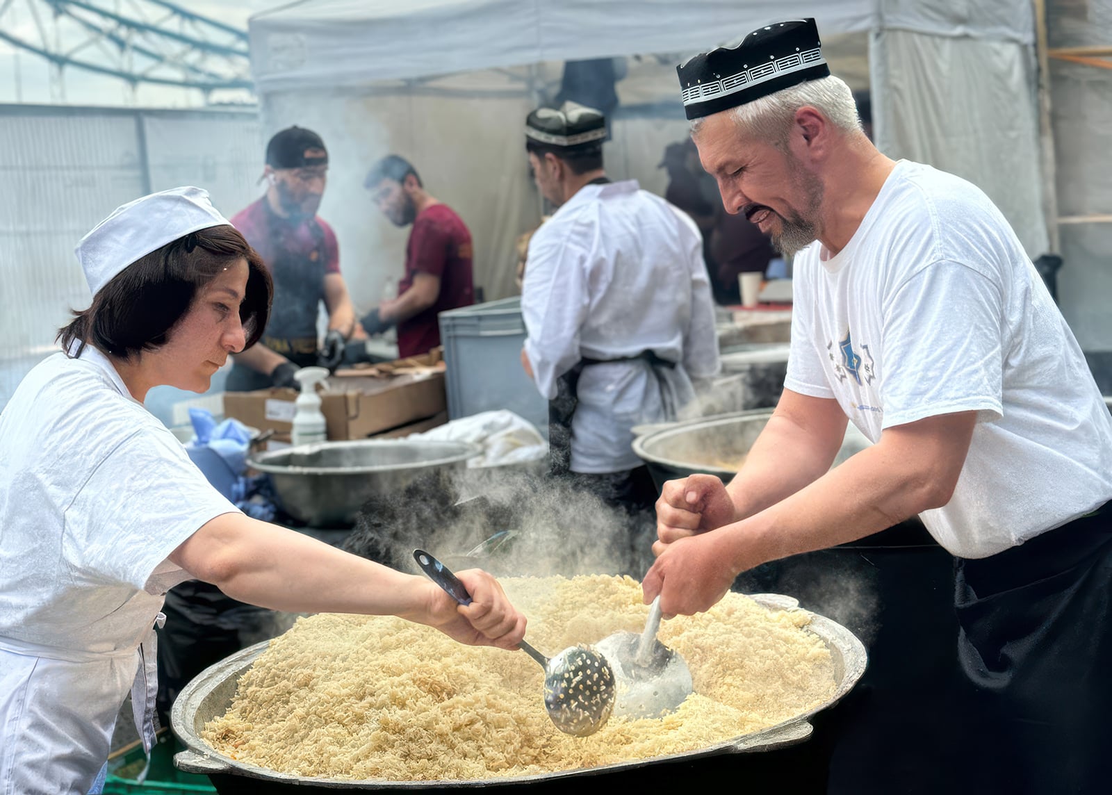 The founders of Samarkand stirring a big pot of food